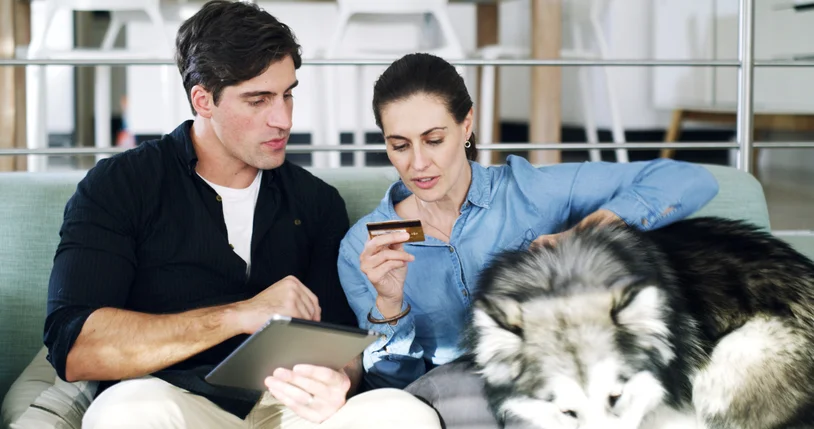 Un proprietario che pianifica il budget pet care controllando le spese per cibo e accessori